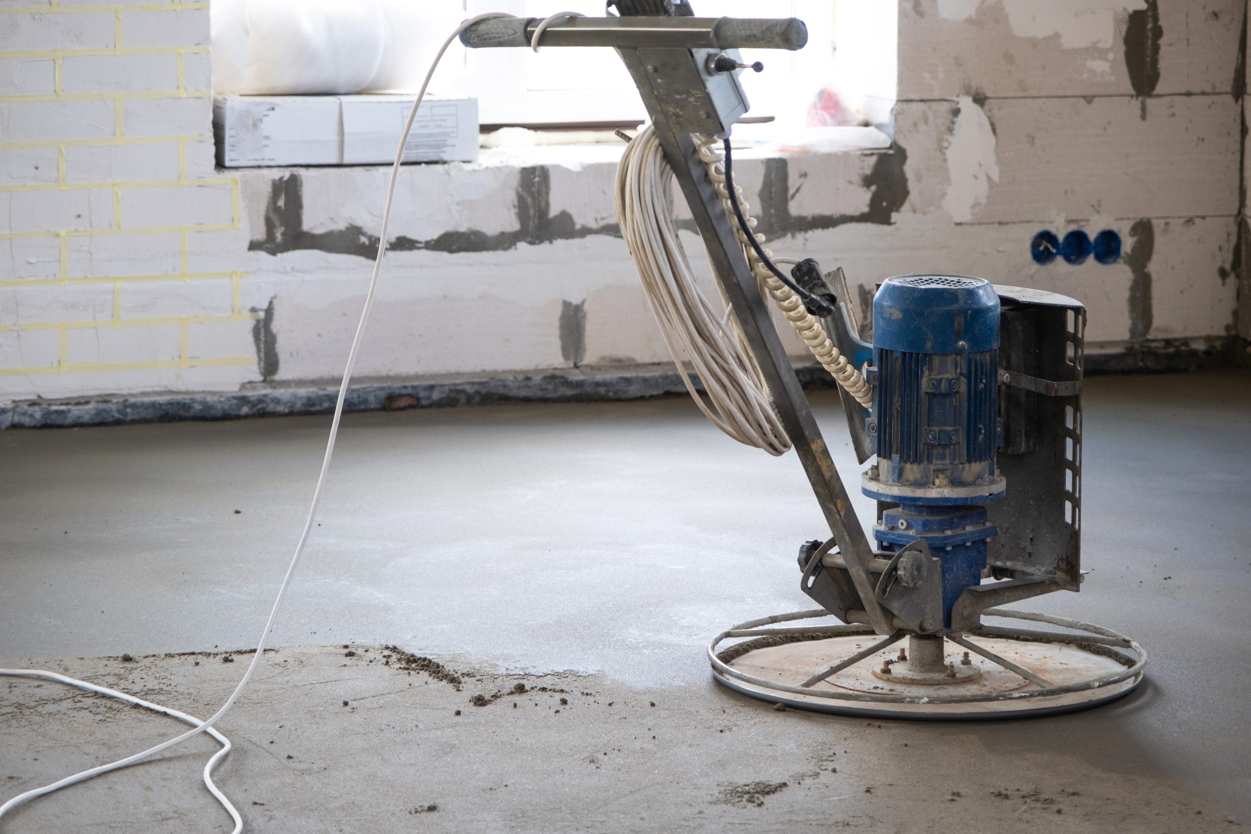 Ramming and grinding of semi-dry floor screed by a machine with